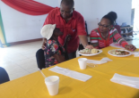 Councillor Trecia Harris-Smiley looks on while Mayor Freeman severs hot meal