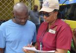 Regional Manager of Property Tax Compliance, Wendye Peterkin (right) explains Property Tax Notices to a resident of Farm Heights